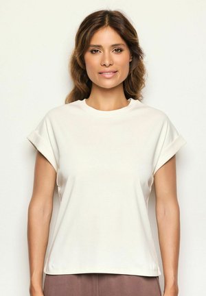 Helles beiges T-Shirt mit Rundhalsausschnitt, gerollten kurzärmligen Ärmeln und lockerer Passform. Glatte Textur, lässiges Design mit schlichter Verarbeitung.