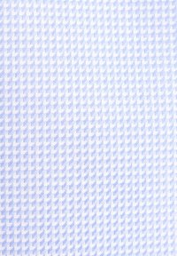 Hellblauer Stoff mit einem sich wiederholenden kleinen Chevron-Muster in Weiß, das ein strukturiertes, gewebtes Erscheinungsbild erzeugt.