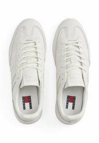 Weiße Sneakers mit einem glatten Lederobermaterial, runder Zehenpartie, Schnürverschluss und dezenten grauen Akzenten. Mit einem Logo-Tab auf der Zunge.