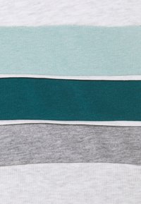 Bavlněná látka se čtyřmi horizontálními pruhy: světle šedý, tyrkysový, světle zelený a tmavě šedý. Každý pruh má hladkou, měkkou texturu.