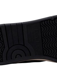 Semelle de chaussure en caoutchouc noir avec un motif de semelle ondulée. Présente un logo en relief "D.A.T.E." et le texte "SE SENTIR BIEN ENSEMBLE."
