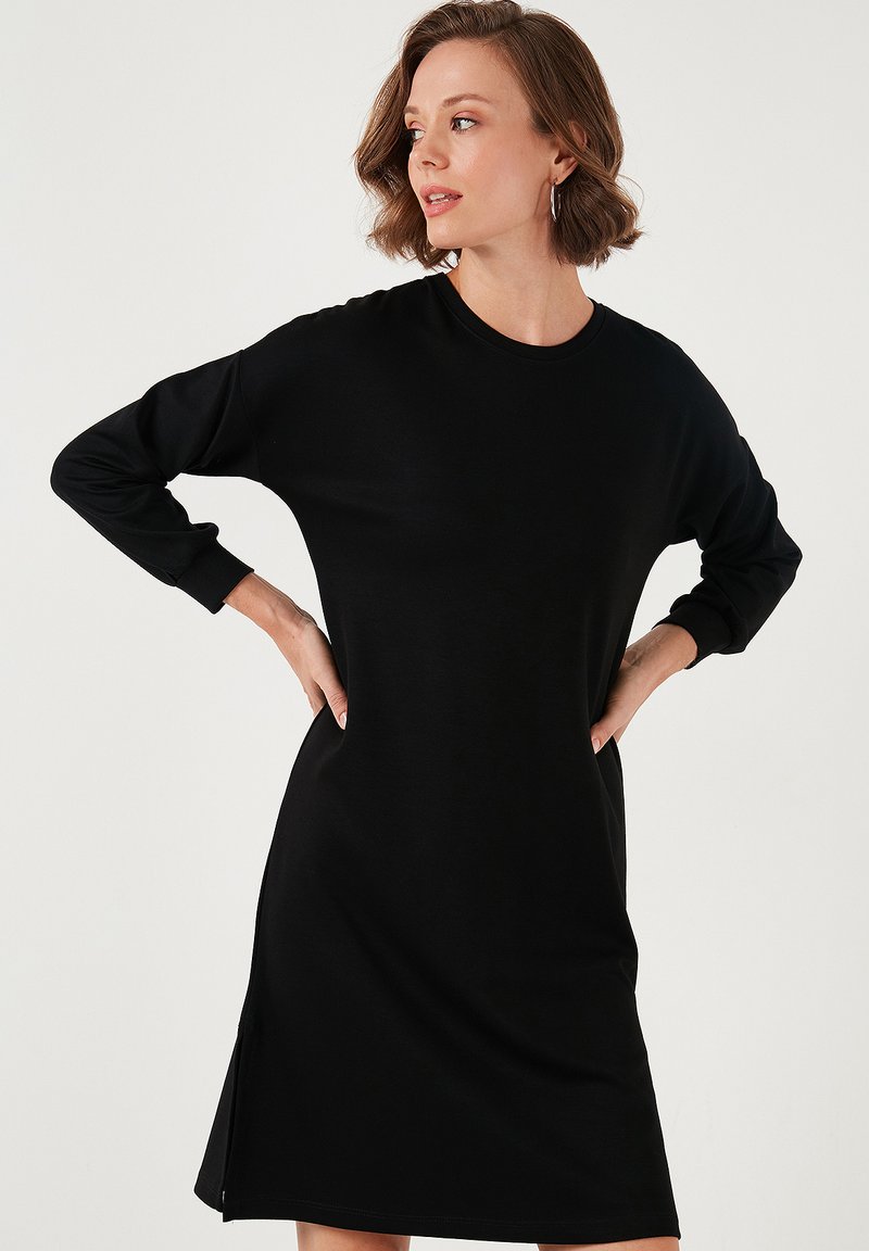 Black long-sleeve dress with a round neckline, relaxed fit, side slits, and soft texture, suitable for casual wear.