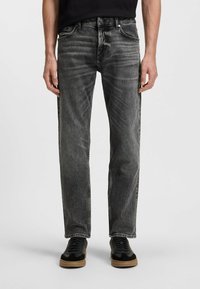 Jeans in denim nero con taglio dritto, caratterizzati da dettagli sbiaditi, cuciture a contrasto, tasche frontali e una vita classica con accessori.