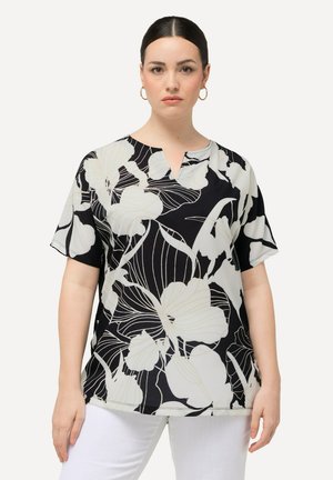 Top negro con estampado floral, de mangas cortas y escote en V, con flores blancas contorneadas en beige sobre una tela suave.