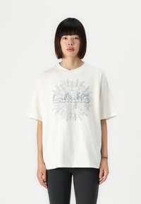Creme oversized t-shirt i bomuld med et grafisk print af ordet "twilight" i sølv, med korte ærmer og rund hals.