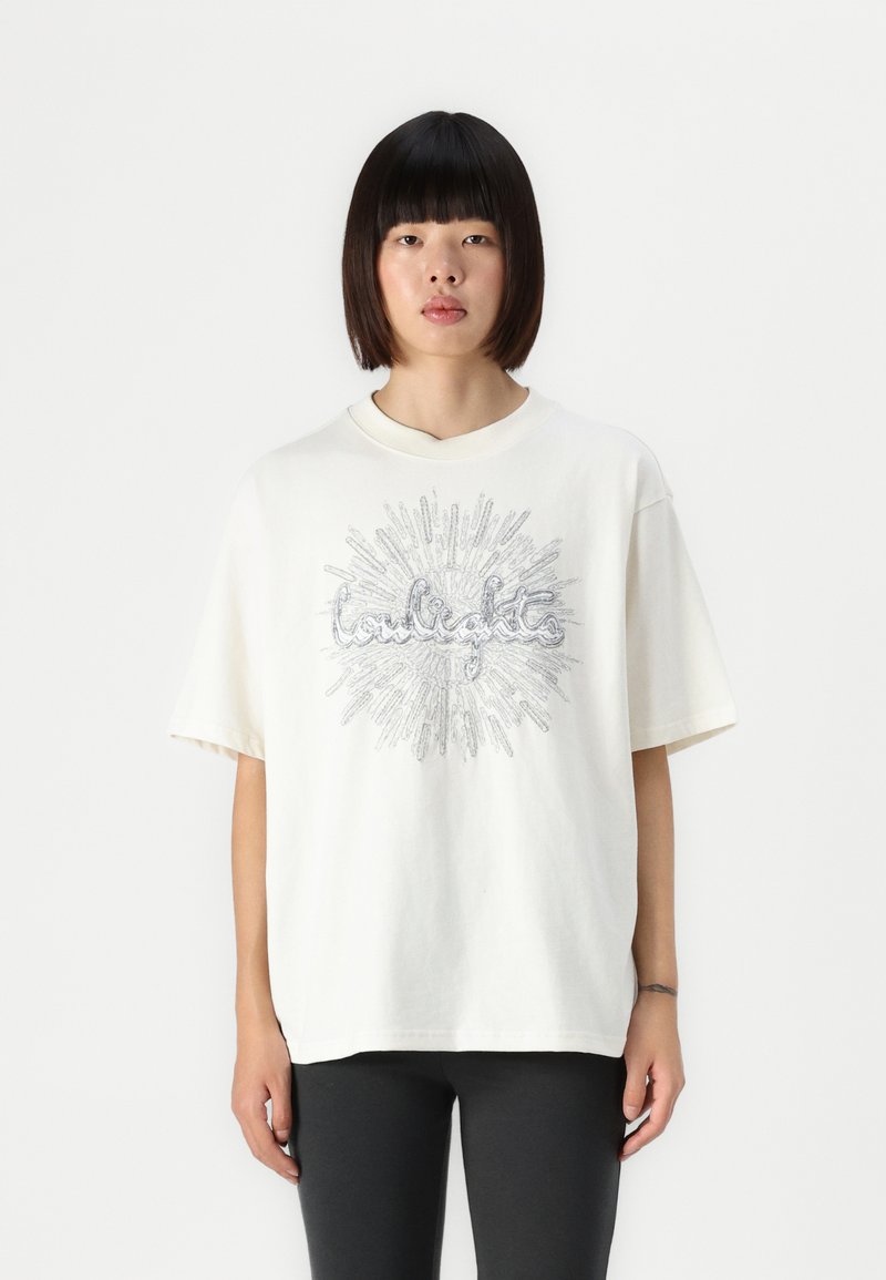 Creme oversized t-shirt i bomuld med et grafisk print af ordet "twilight" i sølv, med korte ærmer og rund hals.