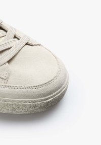 Beiger Wildleder-Sneaker mit strukturiertem Gummisohle, abgerundeter Form und flachen Schnürsenkeln. Verfügt über subtile Nähte und keine sichtbare Markenkennzeichnung.