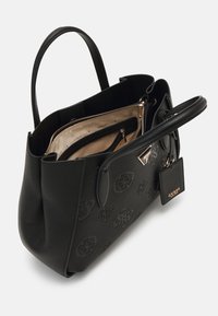 Sac à main Guess en cuir noir avec logos embossés, doubles poignées, intérieur en tissu beige et compartiments zippés, vue en angle montrant le dessus ouvert.