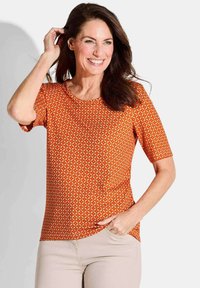 T-Shirt mit kurzen Ärmeln in Orange, das ein Diamantmuster, einen runden Ausschnitt und einen abgerundeten Saum aufweist, aus weichem, leichtem Material.