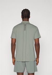 Kortermet sportskjorte i lysegrønt stoff med rett snitt. Funksjoner en vertikal "BORG"-logo på baksiden og matchende shorts.