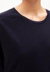 Námořnická modrá bavlněná trička s kulatým výstřihem a krátkým rukávem, s měkkou texturou a minimalistickým designem.