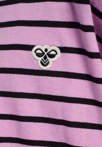 Lilla stribet stof med sorte linjer; har et broderet bi-logo i hvidt og sort på venstre side. Blød tekstur.