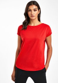 T-shirt rouge à manches courtes avec un col rond, fabriqué en tissu lisse, présentant une coupe décontractée et un ourlet droit.