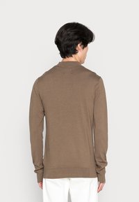 Brown long-sleeve knit sweater with a ribbed collar and hem, featuring a smooth texture and a casual fit.