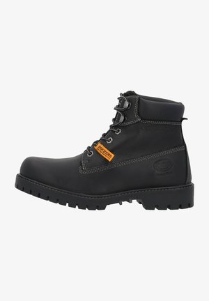 Schwarze Lederknöchelboots mit gepolstertem Kragen, schwarzen Schnürsenkeln, orangefarbenem Markenetikett und strukturiertem Gummiboden mit tiefen Profil für Traktion.