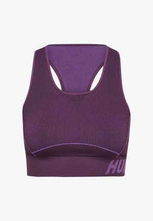 Lilla sportsbh med ribbet tekstur, racerback-design og kontrasterende syninger. Har en bred kant med ordet "HUM" trykt i hvid.