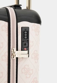 Valigia rigida in tessuto rosa chiaro con motivo a diamante, dotata di lucchetto combinato, doppie cerniere e dettagli in hardware color oro.