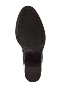 Semelle de chaussure noire avec une finition lisse, marquée de lignes pour l'adhérence, et une forme de pointe arrondie. Comprend un logo subtil près du talon.