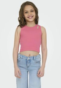 Haut court rose à côtes avec un design sans manches et de petites découpes. Associé à un jean en denim bleu clair taille haute. Fond uni.