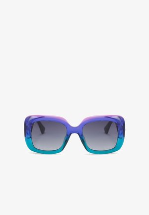 Zonnebril met een gedurfde rechthoekige vorm, voorzien van een kleurverloop van paars naar blauw, getinte lenzen en een glanzend, dik montuur.