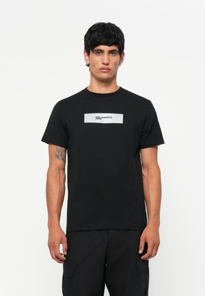 Svart bomull T-skjorte har rund hals og et sølvfarget rektangulært logo-trykk med teksten "KARL LAGERFELD JEANS" på forsiden.