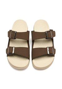 Sandales brunes avec deux larges sangles, boucles métalliques et une semelle texturée beige. Design plat avec une finition lisse et des matériaux durables.