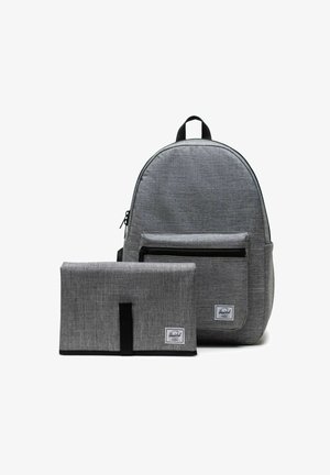 Sac à dos en tissu gris avec une poche zippée à l'avant et un organisateur rectangulaire pliable assorti, tous deux arborant une étiquette de marque blanche.