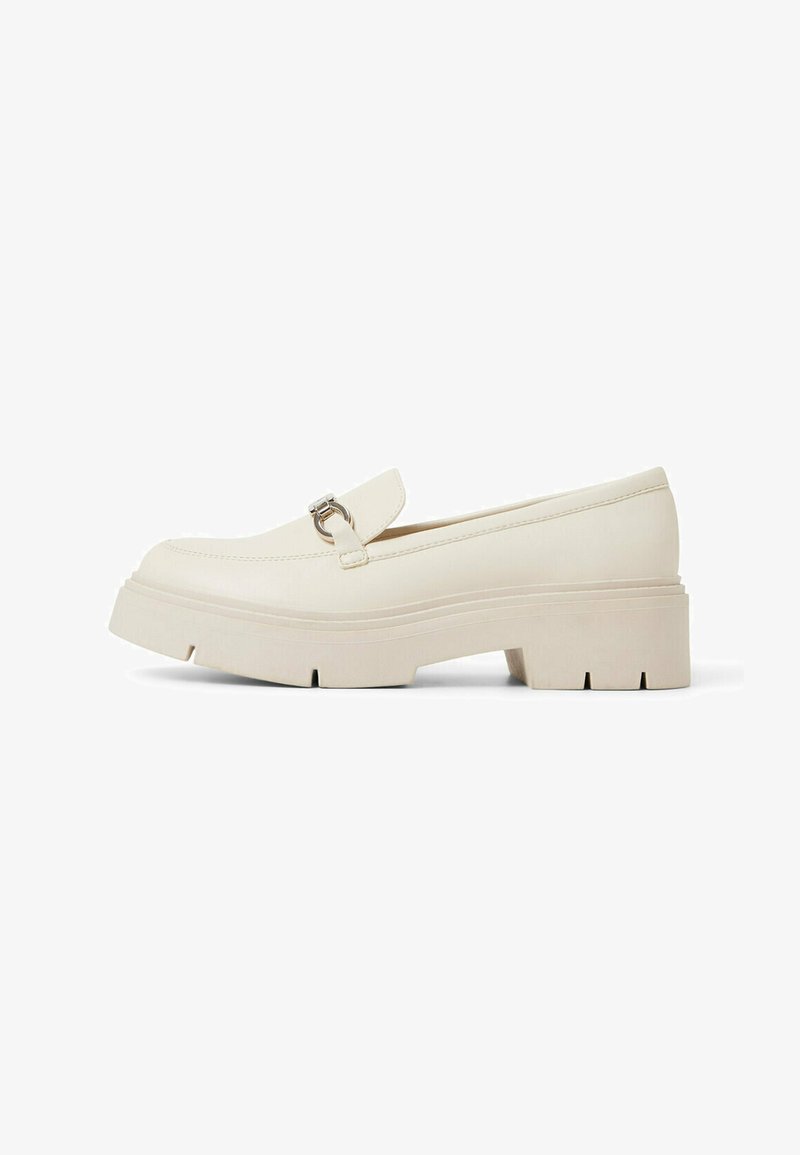 Fette weiße Loafer mit flacher Sohle, glattem synthetischem Material, runder Zehenform und silberfarbener Schnalle auf dem Blatt.