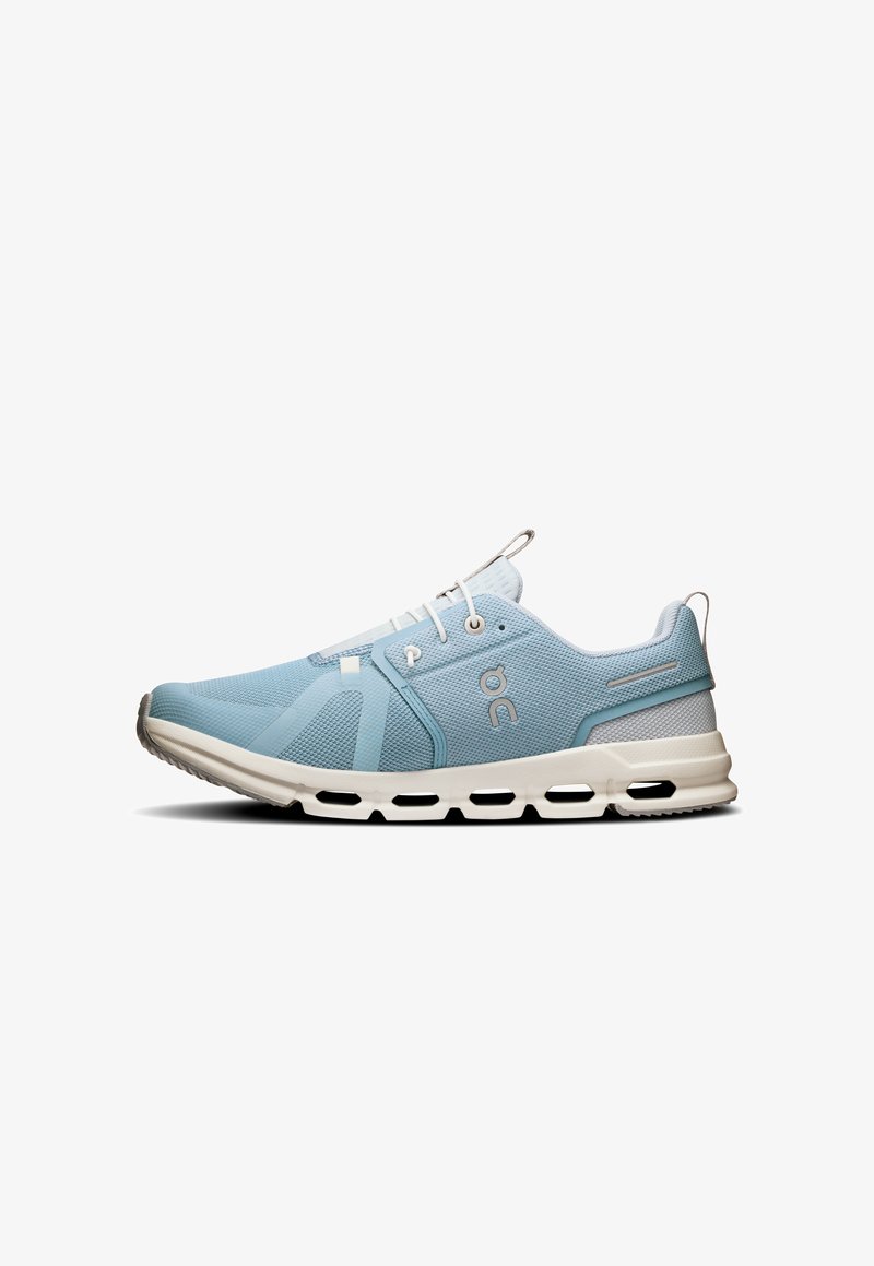 Kék sportcipők hálós felsőrésszel, minimalista dizájnnal, kerek orral, és fehér talppal, amely szellőzőnyílásokkal és húzófüllel rendelkezik.