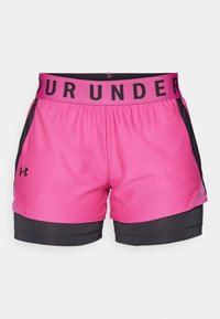 Shorts sportivi rosa con cintura nera che presenta il testo "UNDER ARMOUR", pannelli in rete laterali e un sottopantalone aderente nero.