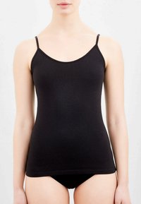 Camisola nera con spalline sottili, realizzata in tessuto morbido e elastico. Design aderente e scollatura rotonda. Completata da biancheria intima nera abbinata.