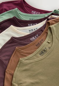 Fem T-shirts stablet sammen i forskellige farver: dyb bourgogne, dæmpet grøn, creme, jordbrun og olivengrøn. Bomuldsstof, rundede halsudskæringer.