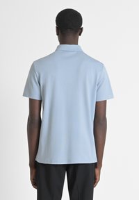 Lichtblauw polo-shirt van soepel materiaal, met korte mouwen en een kraag. De achterkant heeft een effen ontwerp met een rechte zoom.