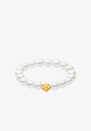 Stretch bracelet made of glossy white beads with a golden floral accent in the center. Smooth texture with round bead shape.