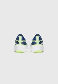 Baskets de sport bleu marine avec une tige en maille respirante, accents verts et une semelle blanche rembourrée avec une adhérence texturée.