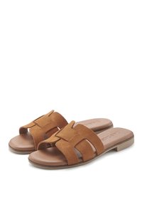 Brown suede slide sandals with an open toe, featuring a crisscross strap design and a flat sole. The interior has a smooth finish.