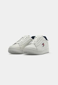 Witte leren sneakers met een ronde vorm, voorzien van een marineblauwe hak en een logodetail in rood, wit en blauw. Geribbelde rubberen zool.