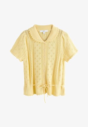 Cardigan tricoté jaune à manches courtes avec fermeture à boutons, motifs ajourés, bords festonnés, large col et ceinture à la taille.