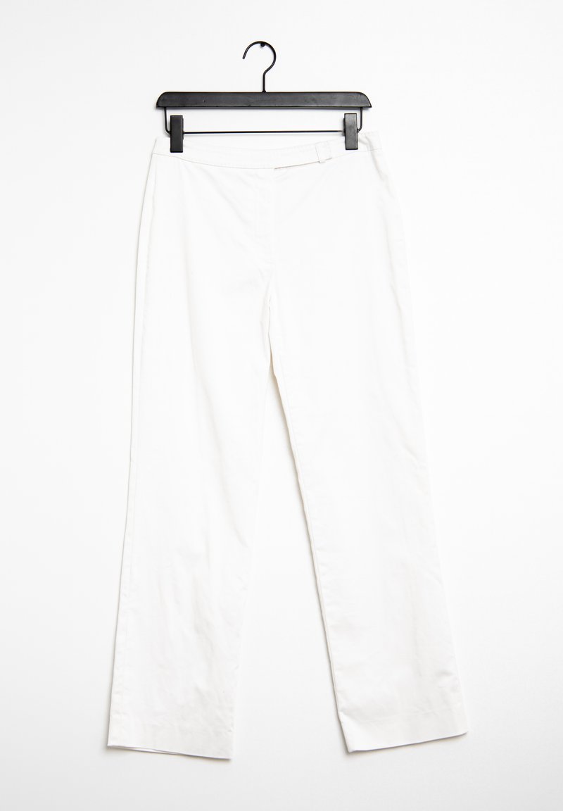 Vita, rakbeniga byxor i ett lättviktigt tyg, med en slät yta och minimalistisk design. Hängande från en svart galge.