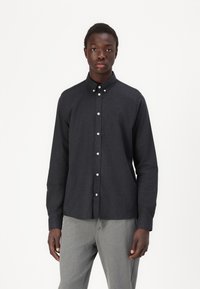 Donkergrijze button-up shirt met een kraag, gemaakt van een gestructureerde stof. Voorzien van witte knopen en een slim fit ontwerp.