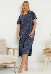 Laivansinisestä puuvillamakoista yöpuvusta, jossa on kukkakuosi, lyhyet hihat ja nilkkapituus. Ominaisuuksiin kuuluu rento istuvuus ja sivuhalkiot mukavuutta varten.