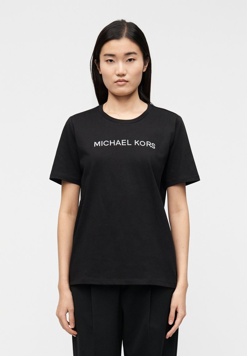 T-shirt preta de algodão com mangas curtas e decote redondo, com o logótipo "MICHAEL KORS" em texto branco contrastante na frente.