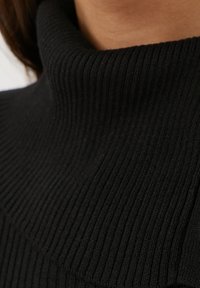 Pull à col montant noir à côtes, avec un motif de tricot texturé et un tissu extensible pour un look ajusté.