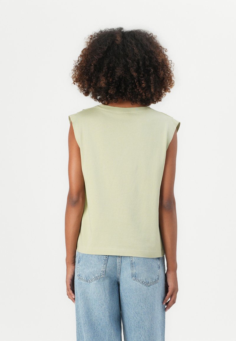 Hellgrünes, kurzärmliges Oberteil aus weichem Stoff mit lockerer Passform. Die Rückansicht zeigt einen Rundhalsausschnitt und eine glatte Textur.