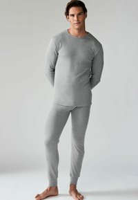 Graues langärmeliges Thermoshirt und passende enganliegende Hosen aus strukturiertem Stoff, mit gerippten Bündchen an den Knöcheln und Handgelenken.