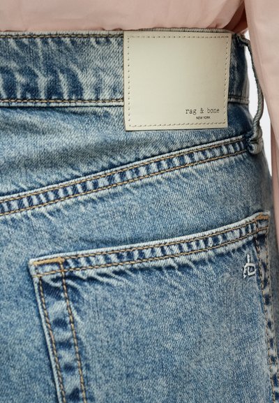 Blaue Jeans aus Denim mit einem Lederetikett, auf dem "rag & bone" in Schwarz gedruckt ist. Auffällige Nähte und eine sichtbare Gesäßtasche.
