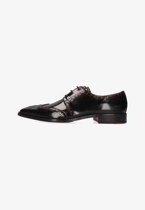 Scarpa da uomo in pelle nera con punta appuntita, dettagli decorativi brogue, accenti rossi sugli occhielli e sulle cuciture, e tacco piatto.