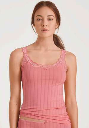 Top a canottiera rosa a coste con rifiniture in pizzo sul collo e sulle spalline, con un piccolo fiocco al centro. Tessuto morbido ed elastico.