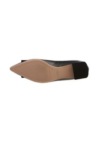 Chaussure noire en cuir à bout pointu avec un design à enfiler, dotée d'une sangle élastique texturée au talon et d'une semelle en caoutchouc beige.