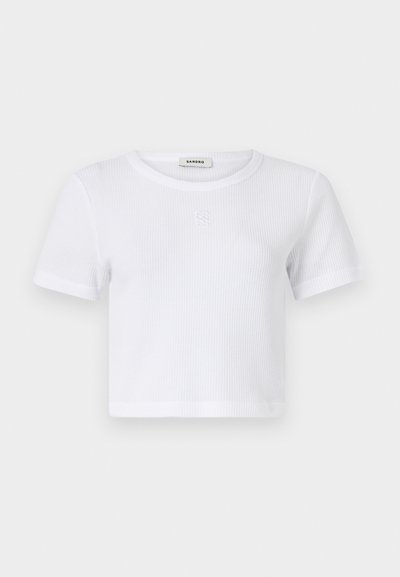 Bijela, kratkodlaka, rebrasta majica s okruglim izrezom. Ima diskretni vez s logotipom sprijeda. Mekani, lagani pamučni materijal.